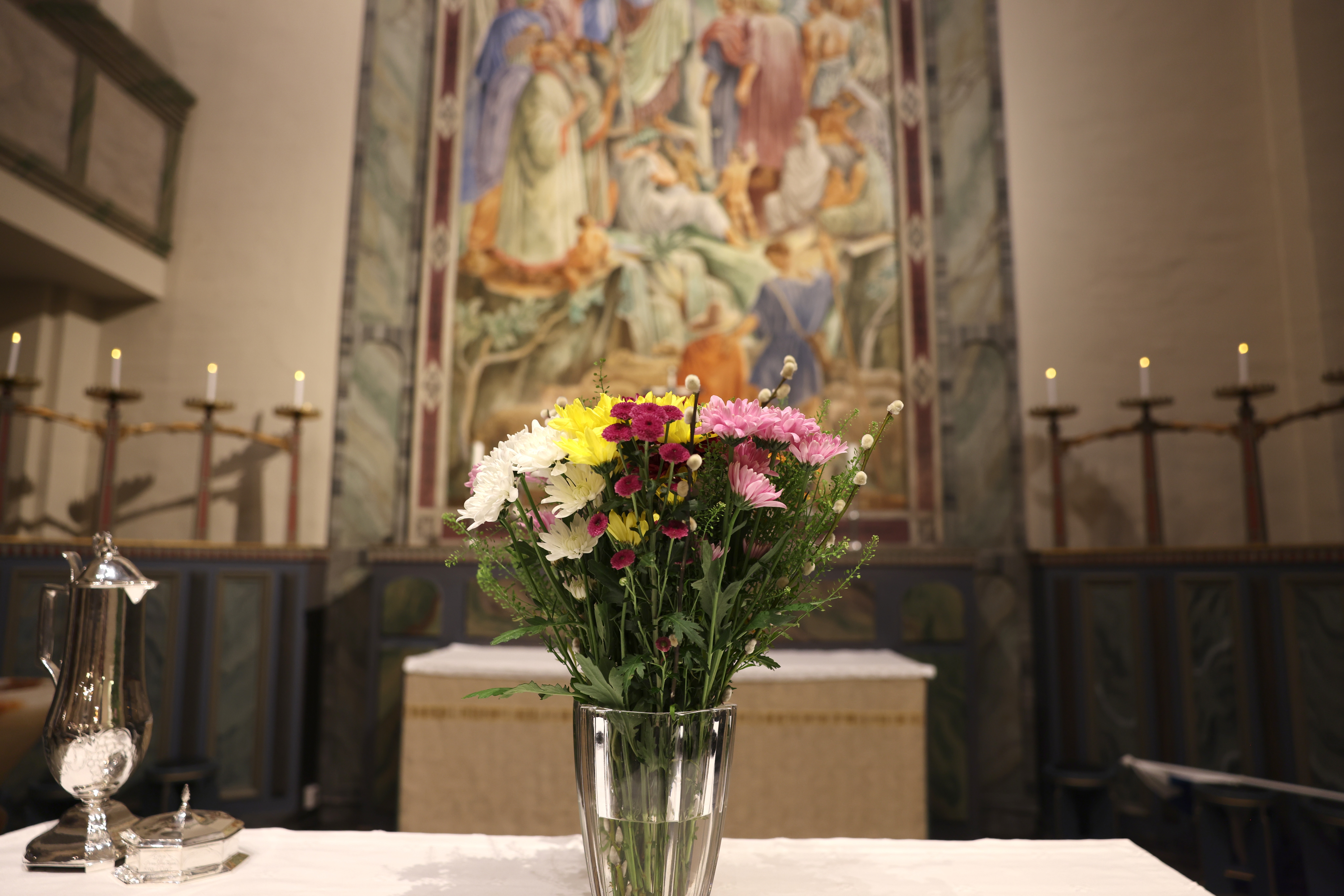 Blomsterarrangemang på altaret i kyrkan.
