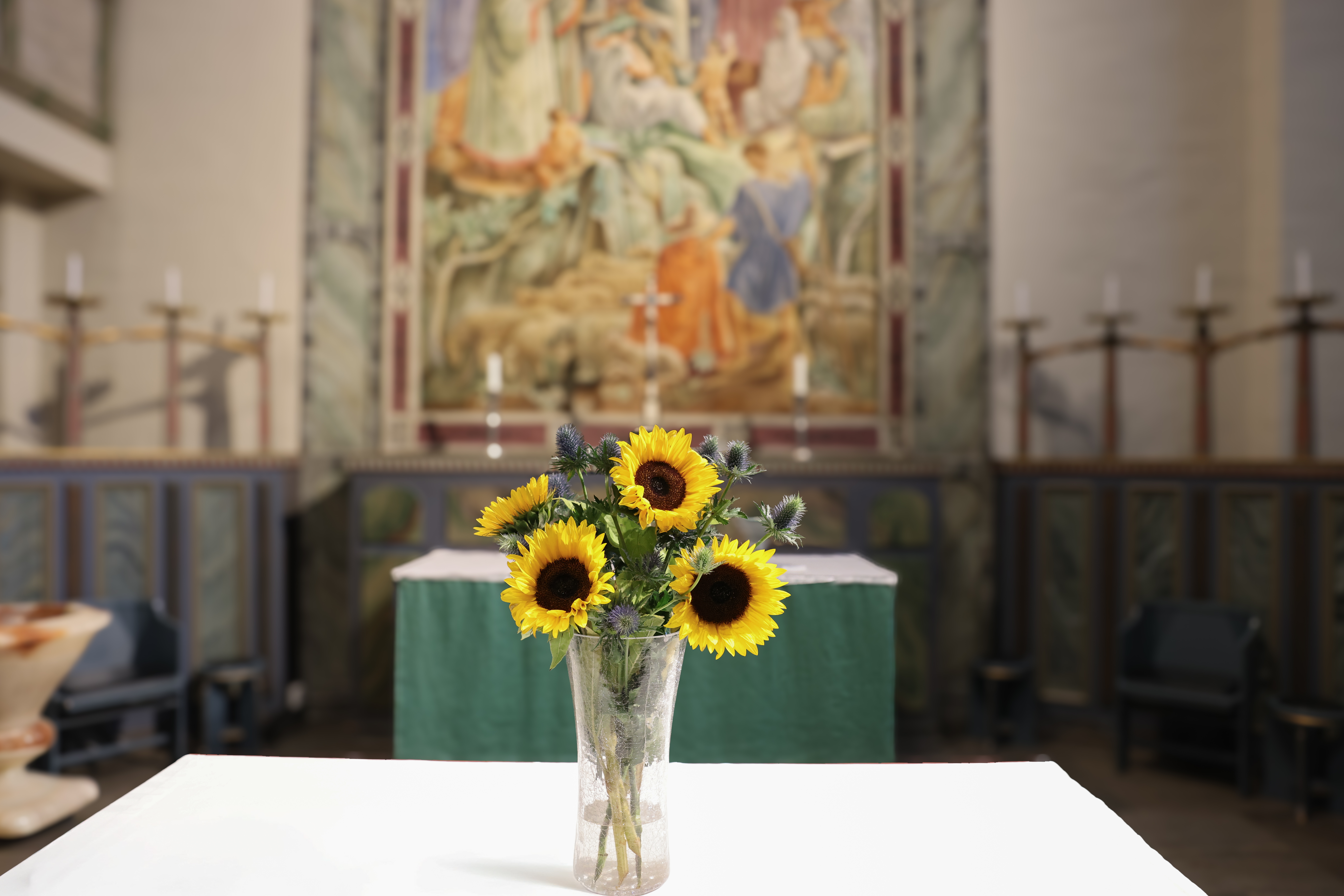 Blomsterarrangemang på altaret i kyrkan.