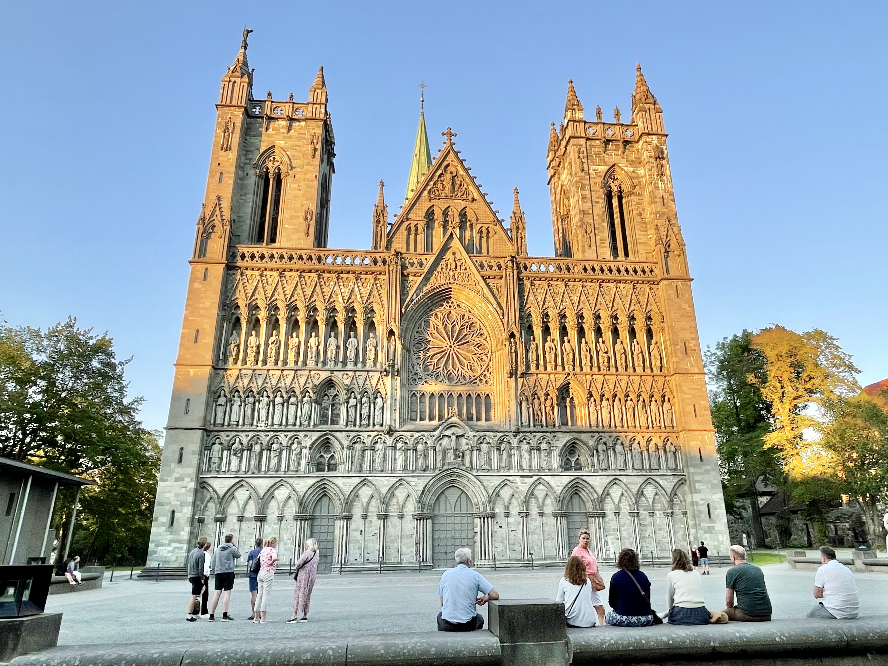 Högmässa till jubileum av 25 år Borgågemenskapen Fasaden av Norges nationalhelgedom Trondheims katedral med de stenhuggna statyerna i kvällssolen på sommaren.