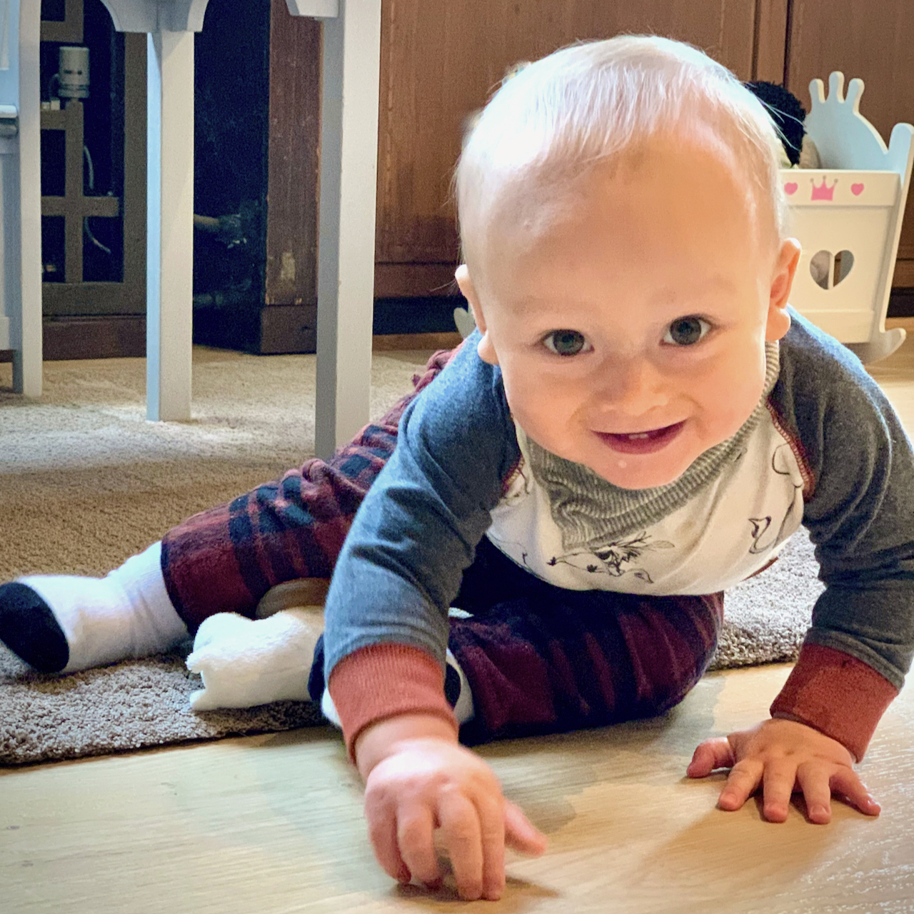 Babycafé på webben Barnet sitter och ler medan han leker.
