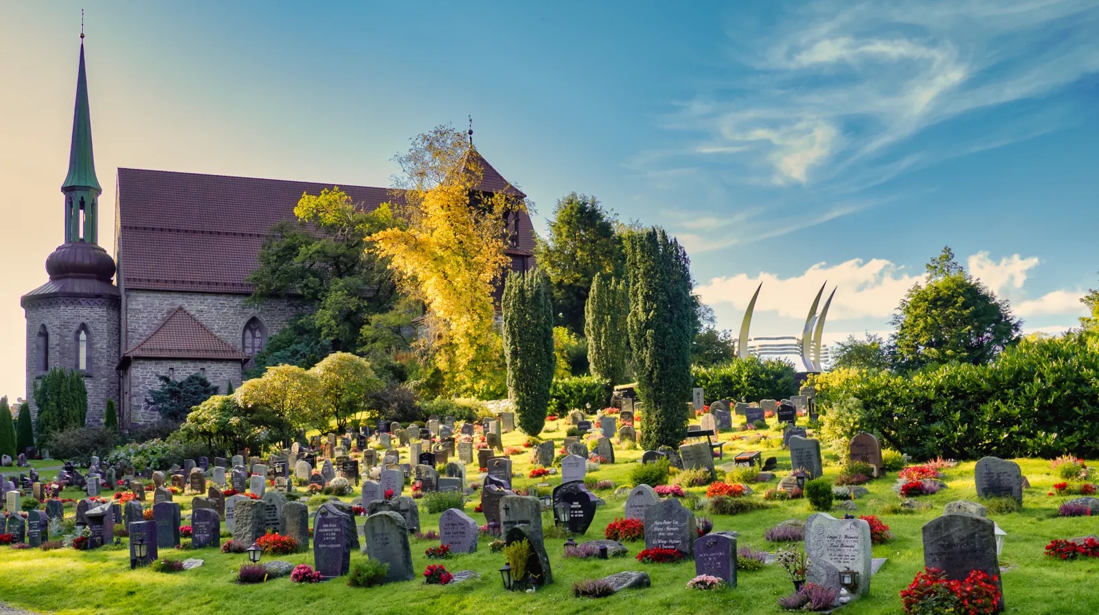 Storetveit kyrka och kyrkogården i Bergen. Kyrkoområdet ser vackert ut på sommaren med grönska och blomsterplanteringar.